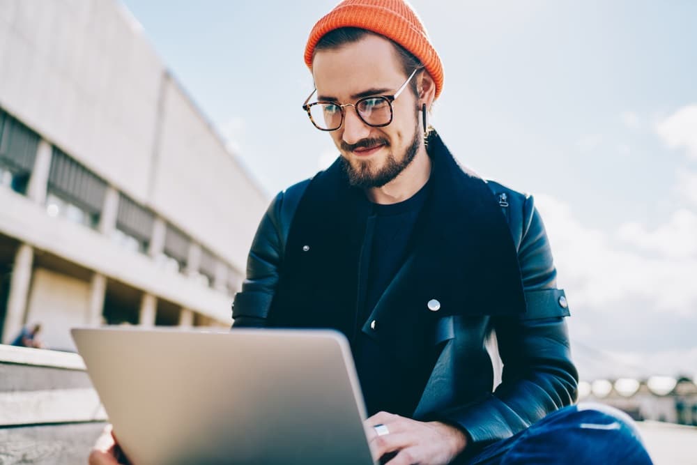 Stages of starting a business. Man working on a laptop outside