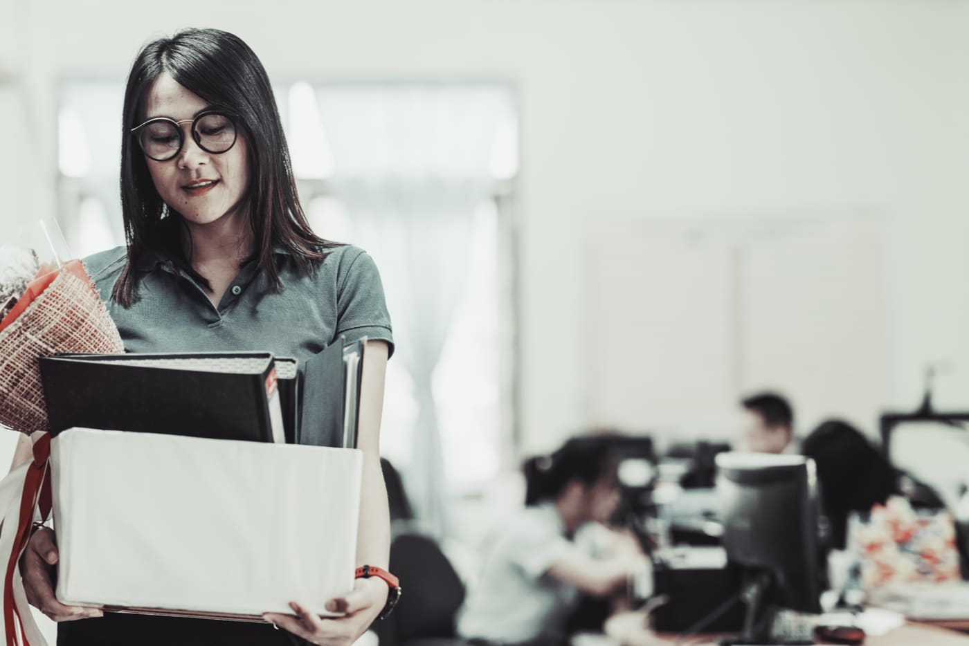 irtisanomisilmoitus. nainen kantaa laatikkoa.