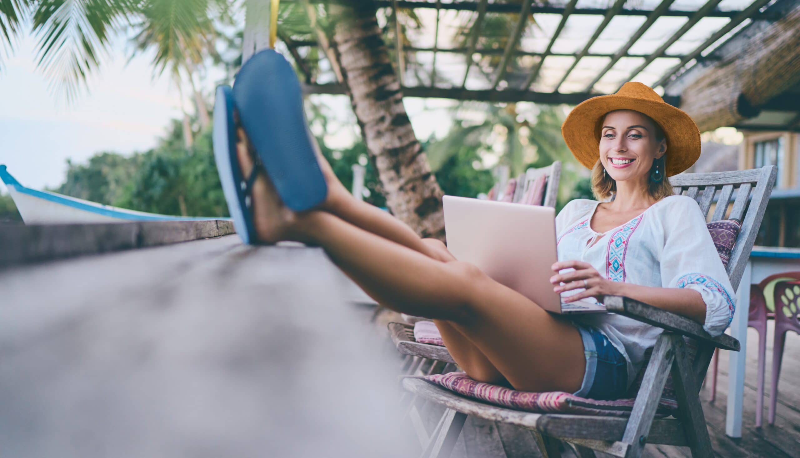 Lomalta paluu. Nainen työskentelee tietokoneella lomakohteessa