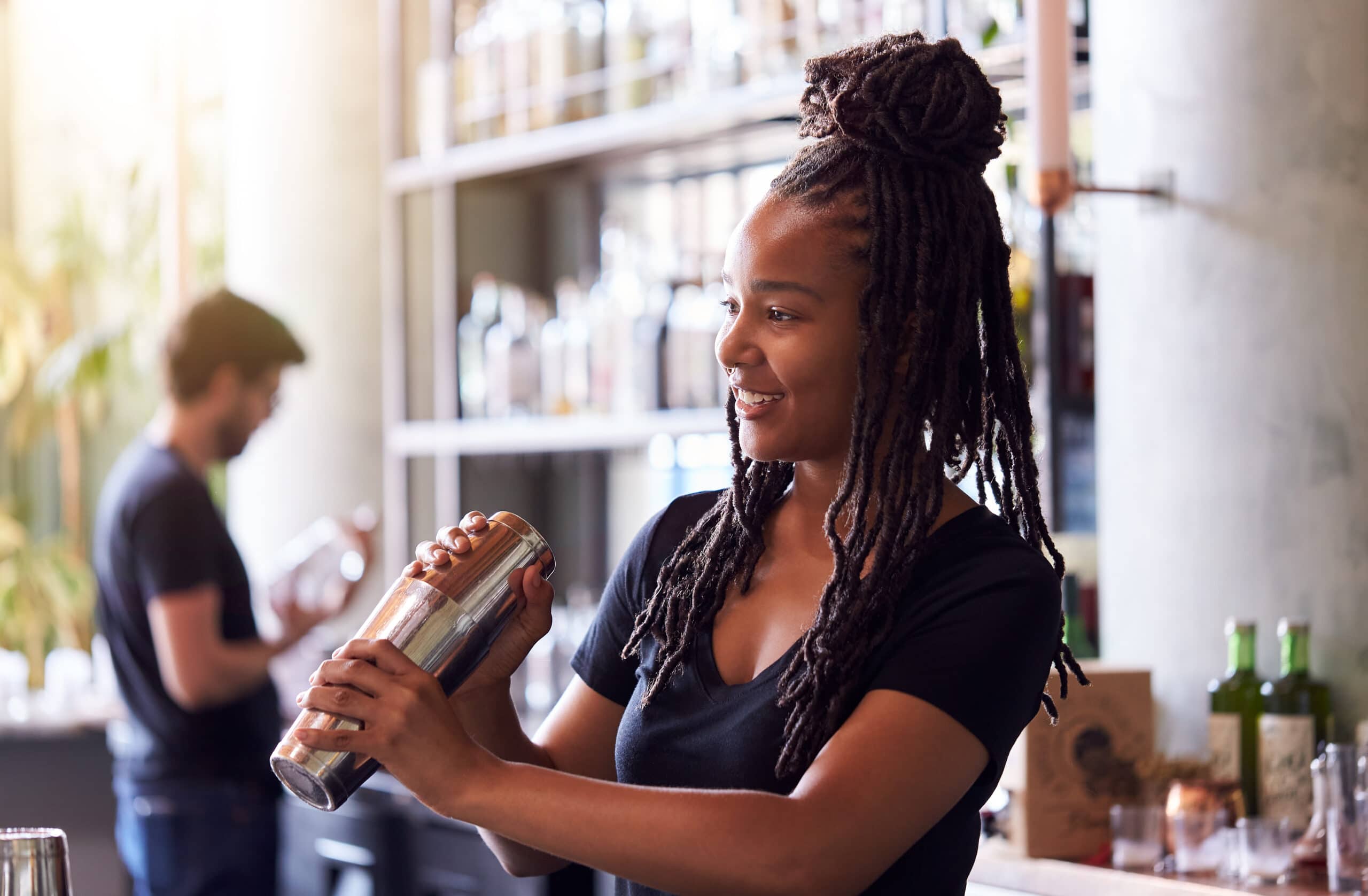 Luvanvaraiset toimialat. Baarityöntekijä tekee drinkkiä.