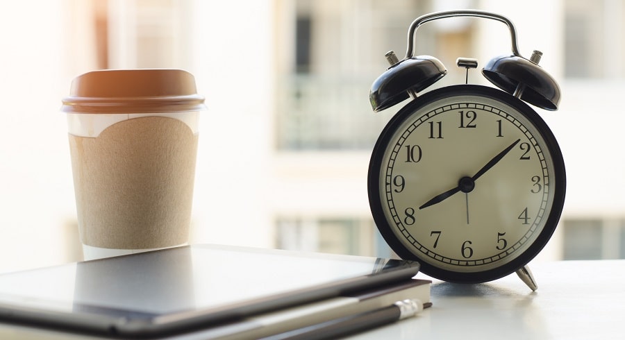 Töitä opiskelijalle. Muistikirja, puhelin, kello ja kahvimuki