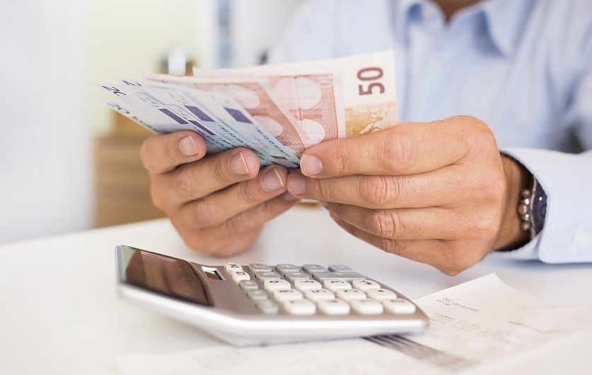 YEL-työtulon määrittäminen. Miesyrittäjä laskee rahoja