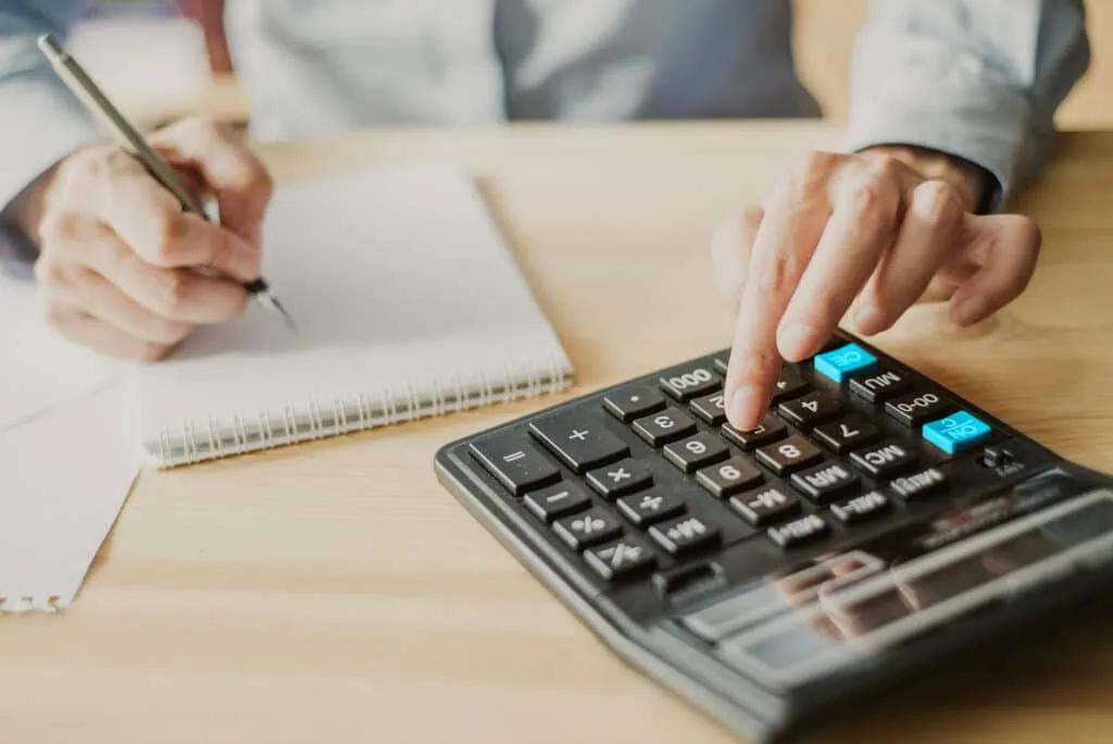 Kuvassa laskimella lasketaan tuloja